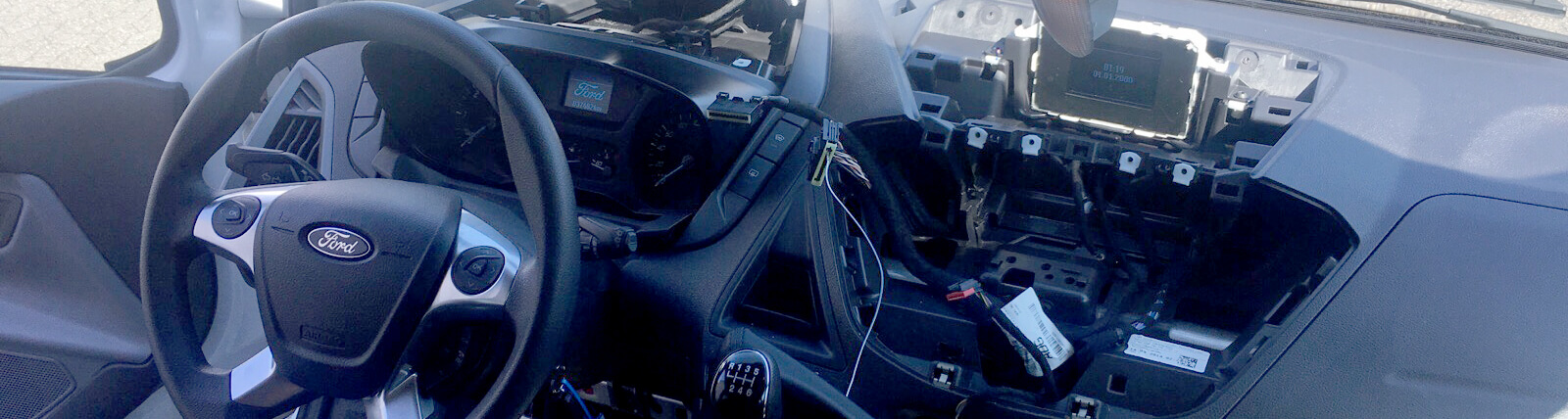 Blick auf den Einbau von Taxi-technik in ein Fordfahrzeug. Man sieht die Ausgebaute Mittelkonsole